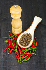 Hot pepper and mill on wooden background