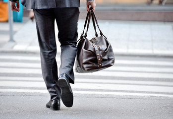 Obraz premium Man in suit with bag, on zebra crossing