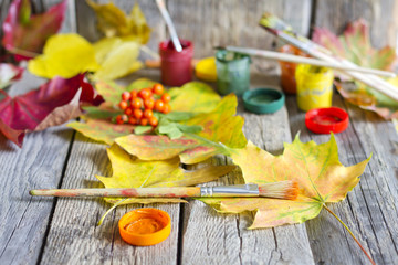 Colors of autumn abstract with paint brush and leaves