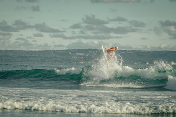 Surfer riding large  ocean wave at the day time