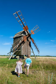 Zwei Kinder betrachten eine alte Windmühle