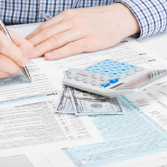 Obraz premium Male filling out 1040 USA Tax Form - studio shot - 1 to 1 ratio