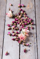 Dried rose buds scattered on a wooden table