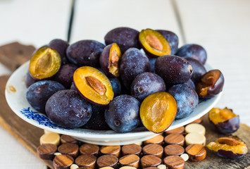 fresh juicy plums on a white board