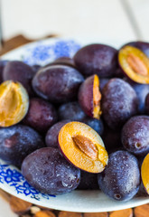 fresh juicy plums on a white board