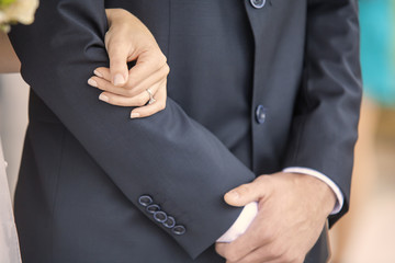 Woman's hand holding man's arm