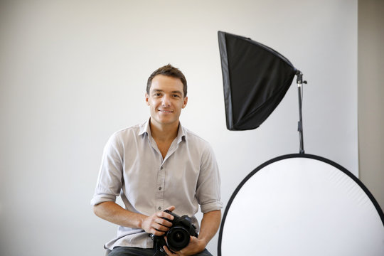 Photographer in studio with lighting equipment