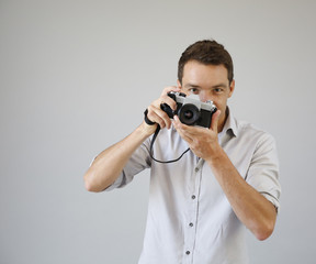 Fototapeta premium Photographer on grey background with vintage camera
