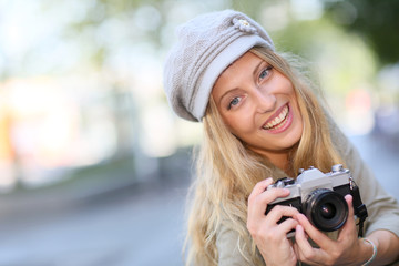 Portrait of young woman with camera