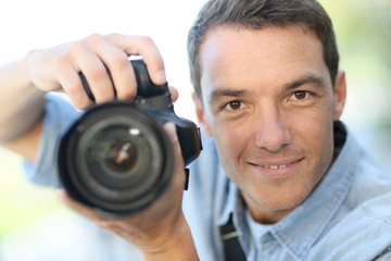 Photographer using reflex camera outside