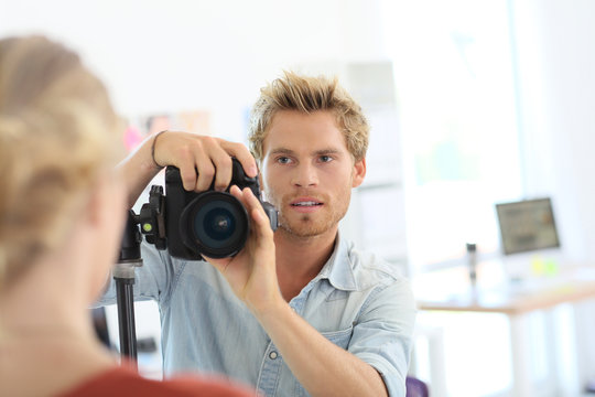 Fashion photographer shooting model in studio
