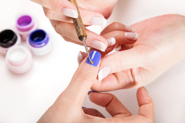 Obraz na płótnie Canvas Nail art gel salon.Applying metal stud on the nail.