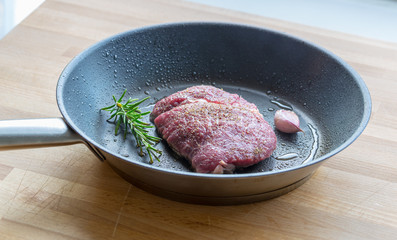 Rindersteak wird in einer Pfanne mit Rosmarin und Knoblauch gebr