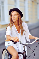 Obraz premium Young woman on a bicycle outdoor portrait