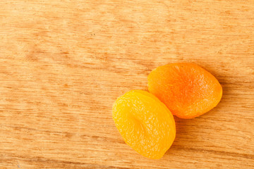 Dried apricots on wooden table background.
