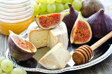 Snack with cheese, honey and fruits, figs and grapes