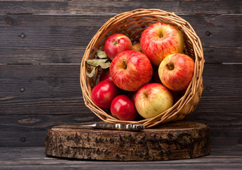 Red apples in basket on wooden textured board