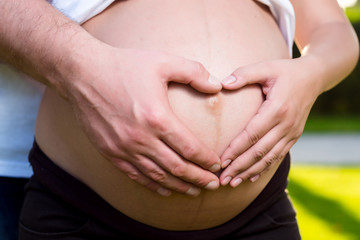 Belly of pregnant woman with her husband hands