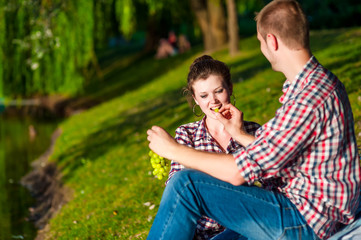 Fototapeta na wymiar happy young couple bite grapes. Toned image