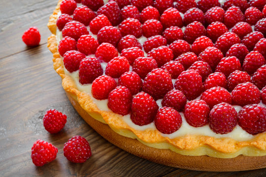 Delicious raspberry tarts on a wooden board
