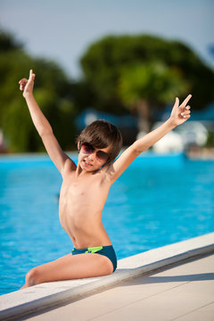 Мальчик у бассейна в солнечных очках