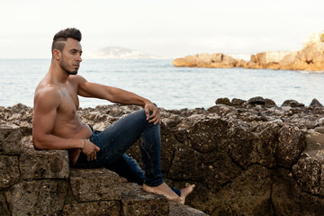 Naklejka na ściany i meble Handsome muscular man on the beach.