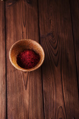 Obraz na płótnie Canvas saffron spice in earthenware bowl on old textured wooden backgro