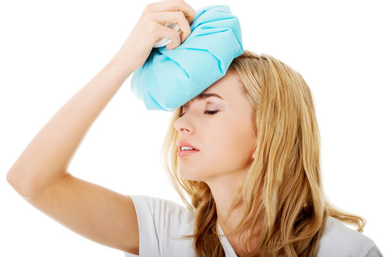 Woman with ice bag, having headache.