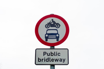 Closeup on public bridleway red and white sign post