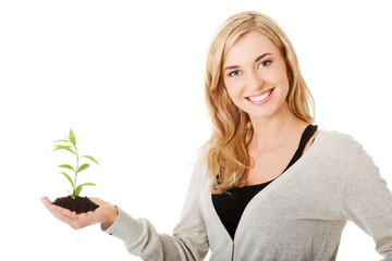 Woman with plant and dirt in hand