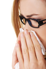 Sick woman blowing her nose