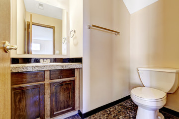 Old wooden bathroom vanity cabinet with granite top