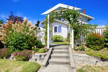Entance wooden archway with fence and flower bed