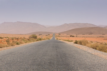 Fototapeta na wymiar Straight road through the desert in Morocco, Africa