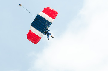 Parachute descending under the clouds