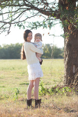 baby and mother strolling on suburban landscape