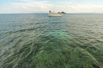 Clean and clear water with sail boats background. Low angle view