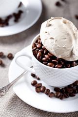 Coffee beans with meringue on top in a white cup