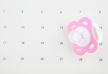 Pregnancy concept delivery due date with calendar and pacifier