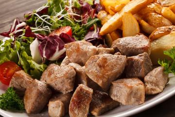 Grilled meat with baked potatoes and vegetables