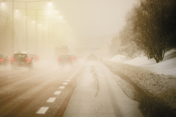 Road with traffic and heavy fog