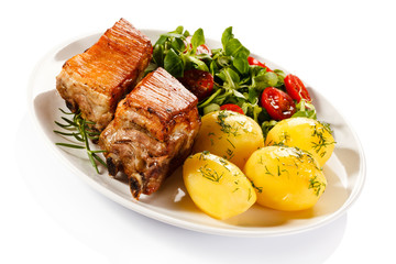 Tasty grilled ribs with vegetables on white background