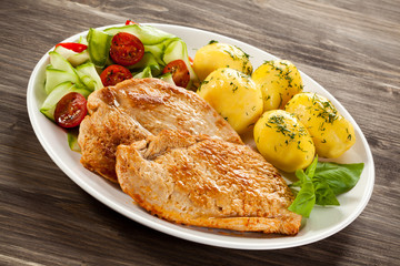 Fried pork chop, boiled potatoes and vegetable salad