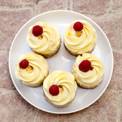 Obraz na płótnie Canvas Cup-cakes close-up with raspberry on top