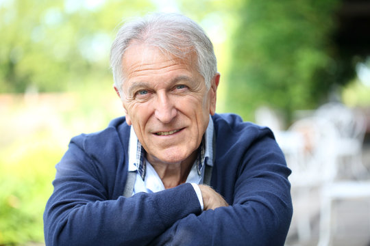 Portrait of senior man sitting in home garden