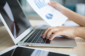 Close-up of business person use laptop with financial diagram