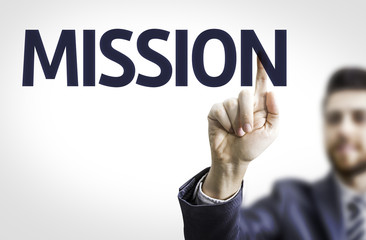 Business man pointing to transparent board with text: Mission