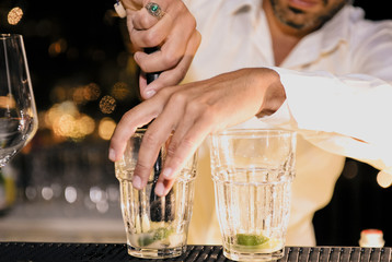 Barman is decorating a cocktail