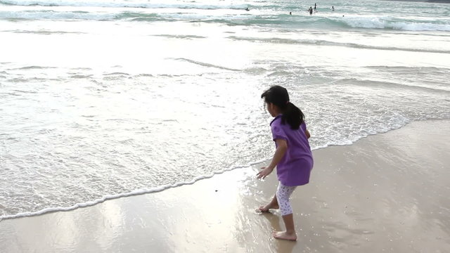 Funny little girl playing on the beach