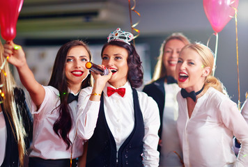 group of girls friends having fun on karaoke party